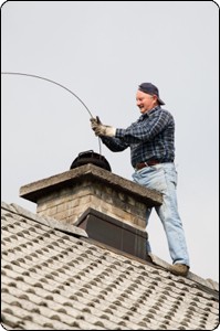 chimney sweep employee working on the roof